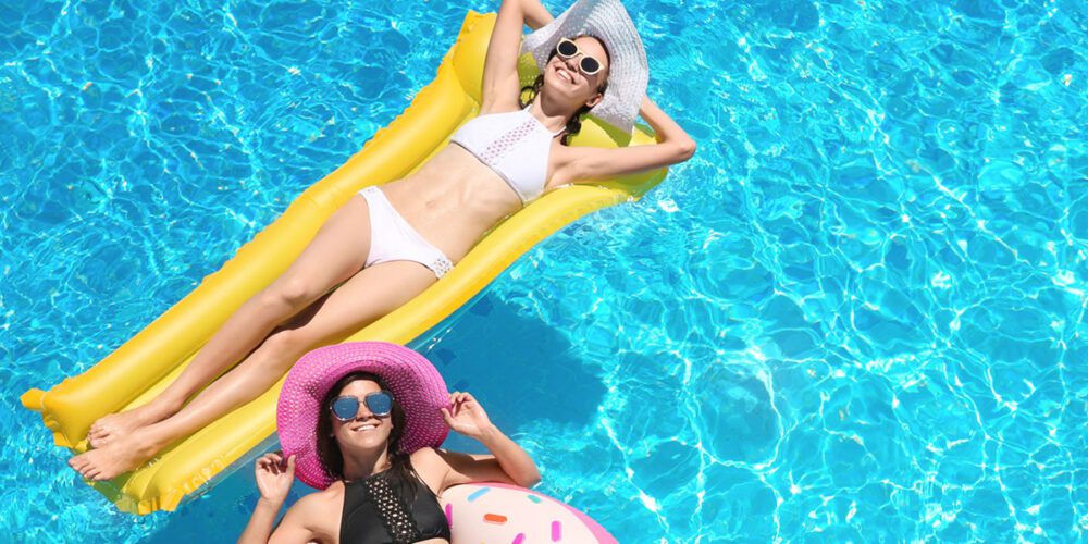 Two women floating in an outdoor pool, offered at The Arno.