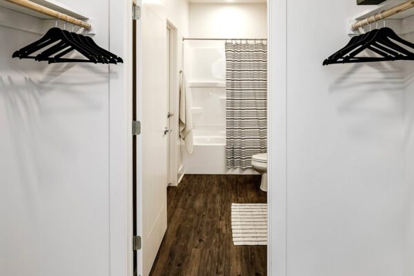 Walk-in closet looking through to bathroom in one bedroom unit at The Arno apartments